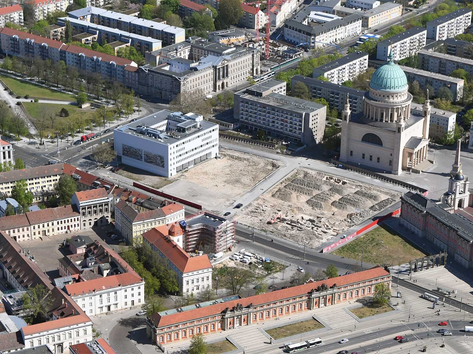 Foto: Luftbild der geräumten Baustelle neben dem Bildungsforum, umgeben von Staudenhof, Nikolaikirche, Landtag, Filmmuseum und Bebauung an der Friedrich-Ebert-Straße.